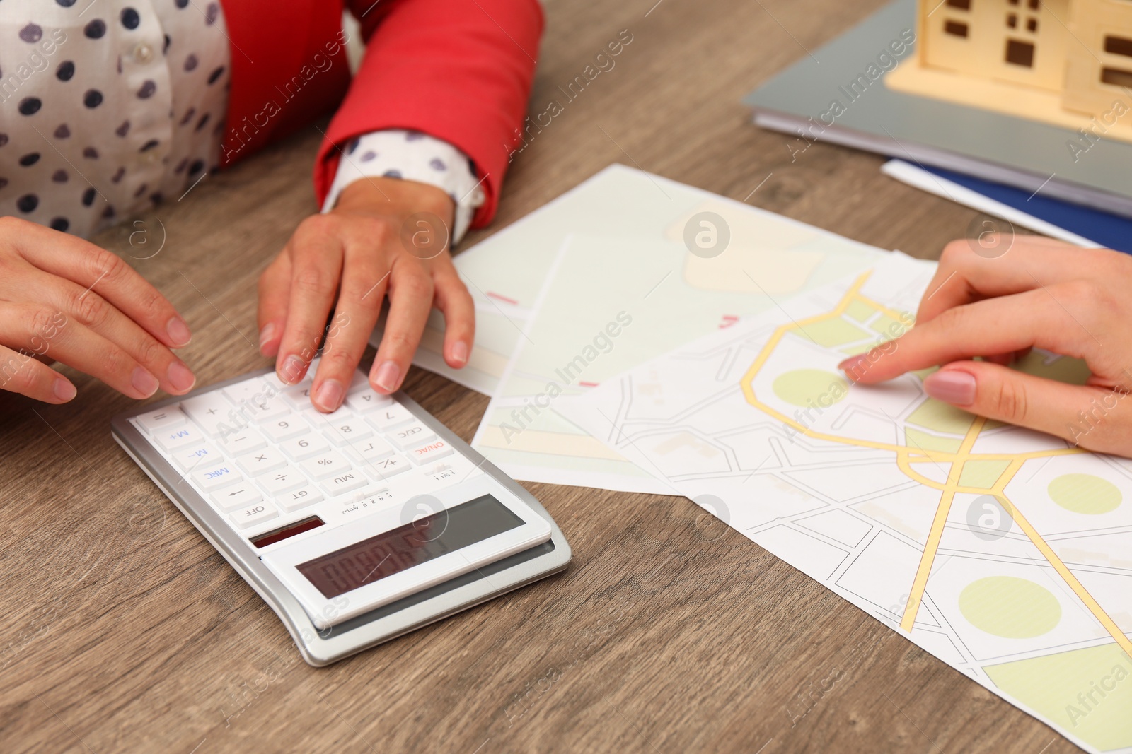 Photo of Real estate agent working with client at wooden table, closeup