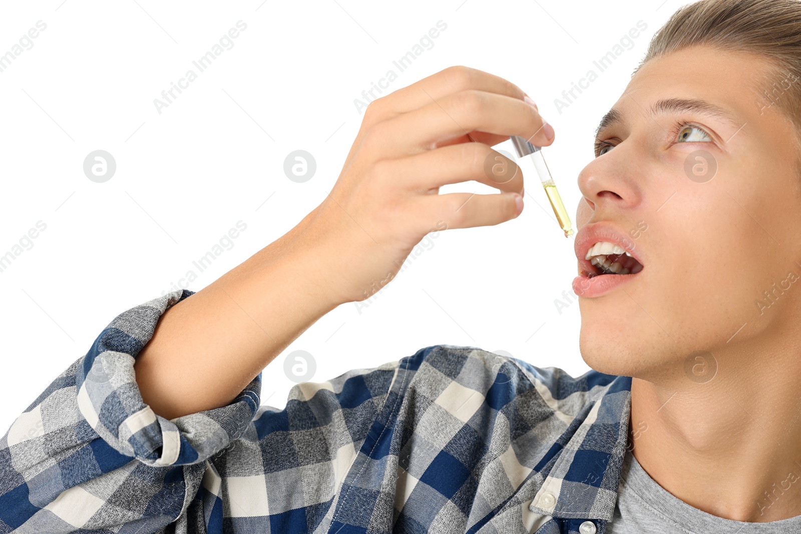 Photo of Young man taking CBD tincture indoors. Herbal extract