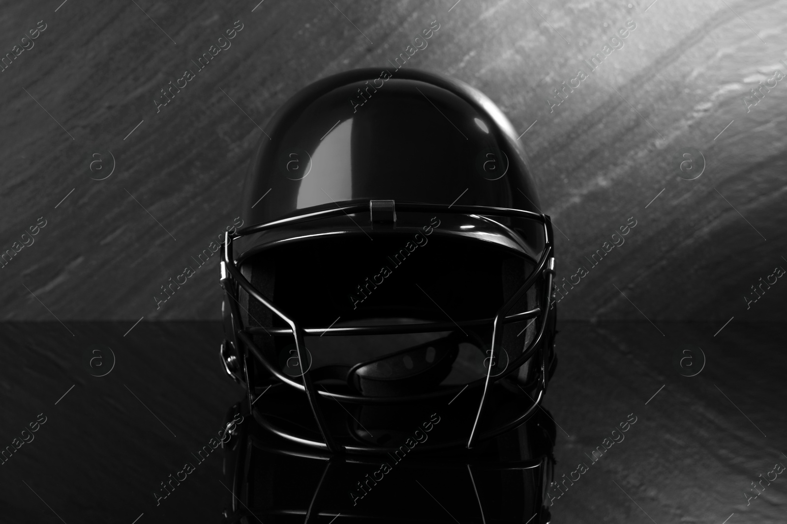 Photo of Black baseball helmet on dark gray background