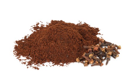 Photo of Pile of clove powder and dried buds on white background. Aromatic spice