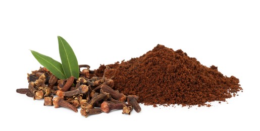 Pile of clove powder, dried buds and green leaves on white background. Aromatic spice