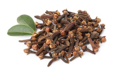 Pile of dry clove buds and green leaves on white background. Aromatic spice