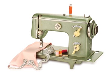 Photo of Sewing machine with pink fabric, measuring tape and spools of threads isolated on white