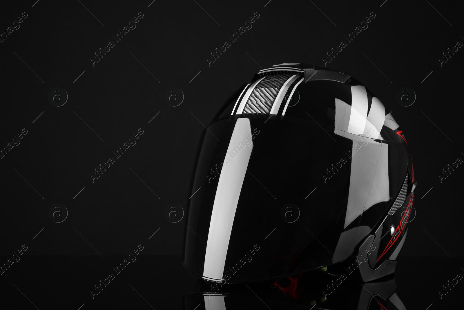 Photo of Motorcycle helmet with visor on black background, space for text