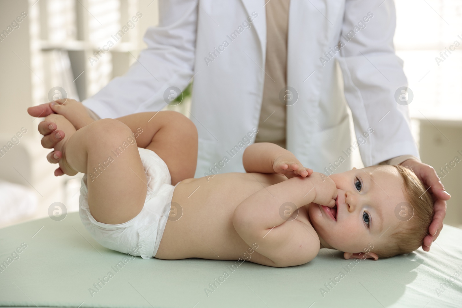 Photo of Pediatrician with little child in clinic, closeup. Checking baby's health