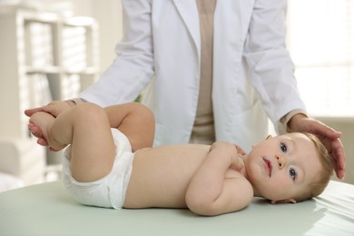 Photo of Pediatrician with little child in clinic, closeup. Checking baby's health