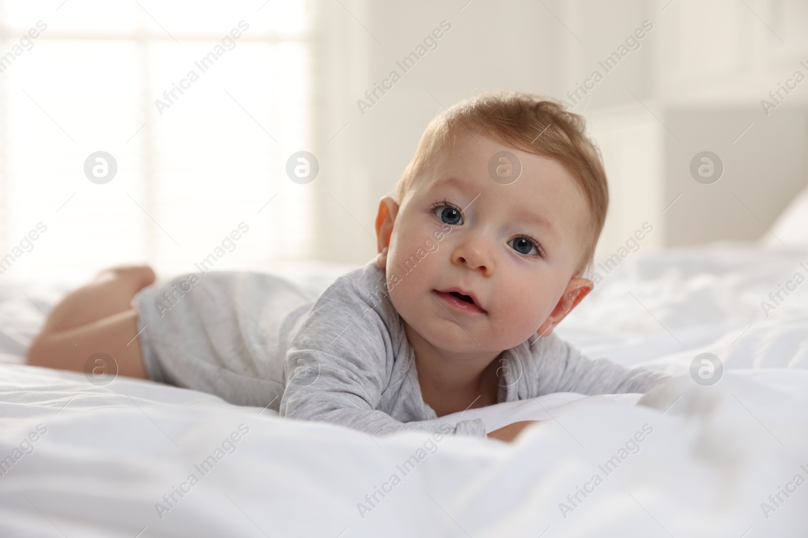 Photo of Cute little baby on bed at home