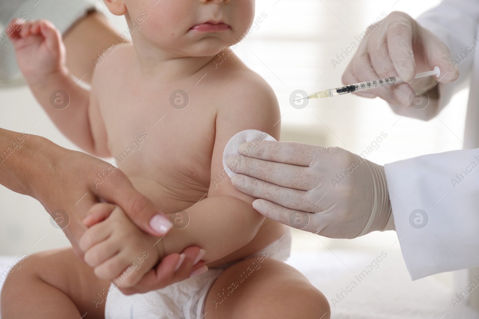 Photo of Pediatrician vaccinating little baby in clinic, closeup