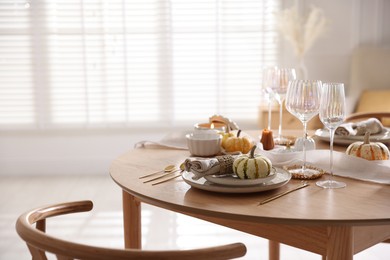 Photo of Stylish table setting with beautiful dishware and autumn decor in dining room