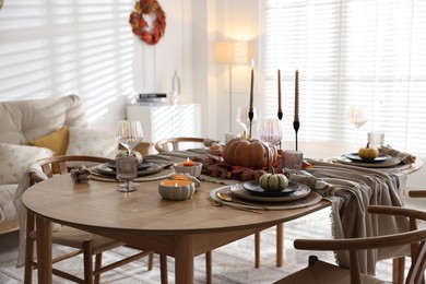 Stylish table setting with beautiful dishware and autumn decor in dining room