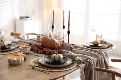 Photo of Stylish table setting with beautiful dishware and autumn decor in dining room