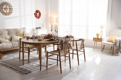 Stylish table setting with beautiful dishware and autumn decor in dining room