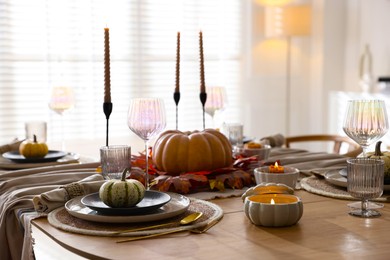 Stylish table setting with beautiful dishware and autumn decor in dining room