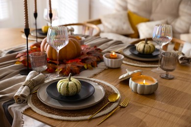 Stylish table setting with beautiful dishware and autumn decor in dining room