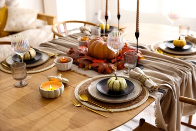 Stylish table setting with beautiful dishware and autumn decor in dining room