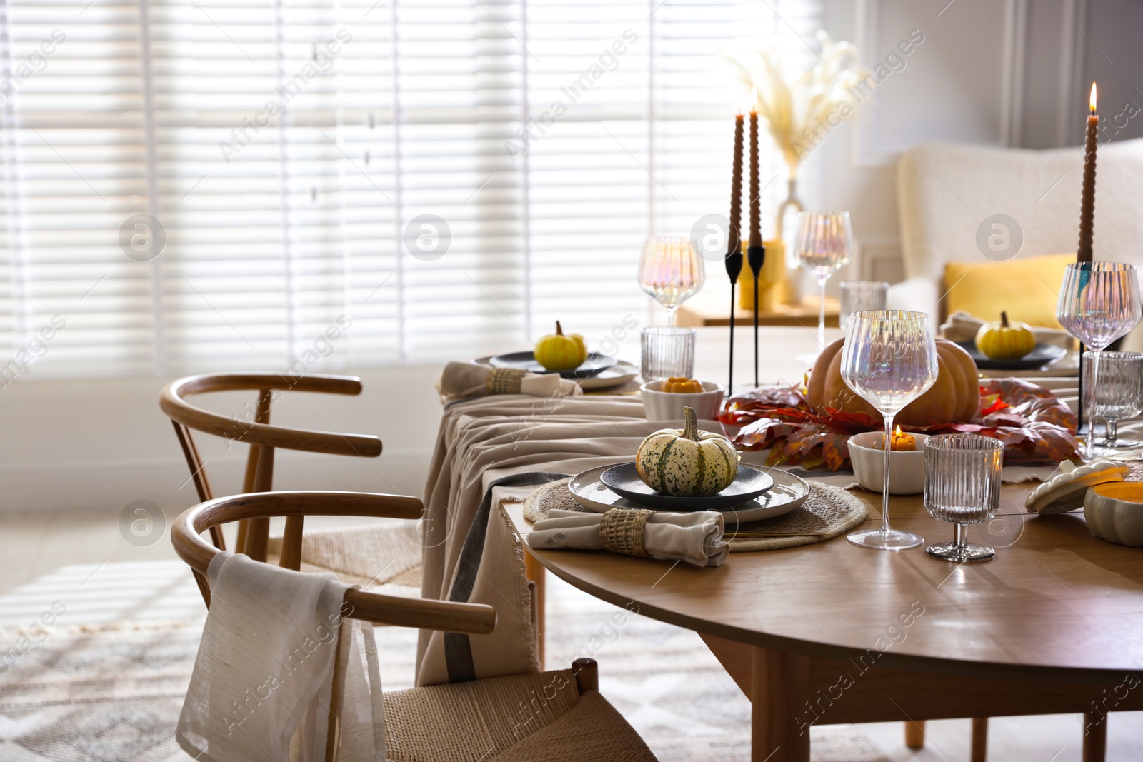 Photo of Stylish table setting with beautiful dishware and autumn decor in dining room