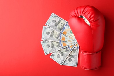 Photo of Boxing glove and money on red background, top view. Space for text