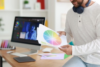 Photo of Designer with color palette in office, closeup