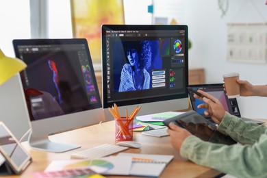 Photo of Designers working at table together in office, closeup