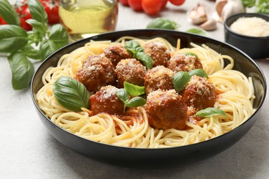 Delicious pasta with meatballs on grey textured table, closeup