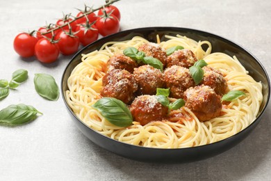 Delicious pasta with meatballs and ingredients on grey textured table, closeup