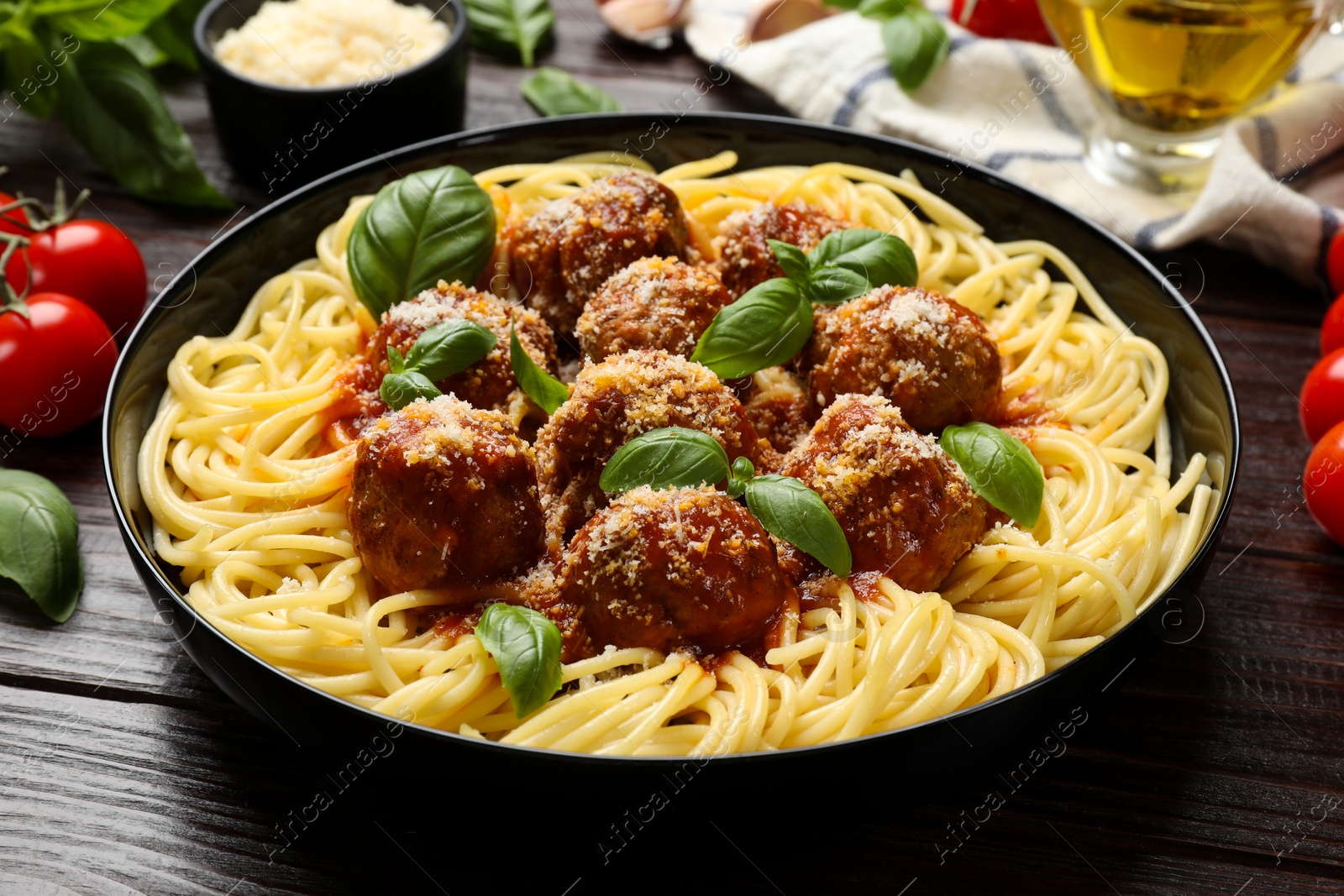 Photo of Delicious pasta with meatballs on wooden table, closeup