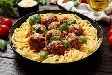 Photo of Delicious pasta with meatballs on wooden table, closeup