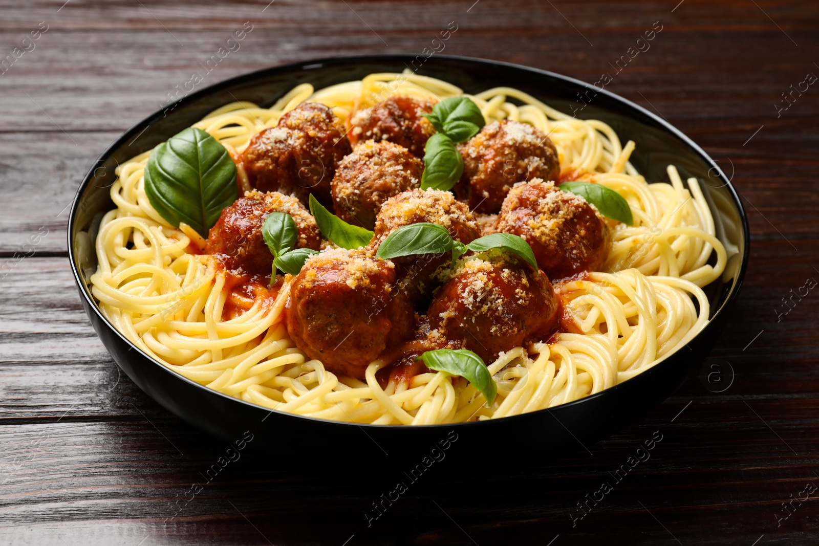 Photo of Delicious pasta with meatballs on wooden table, closeup