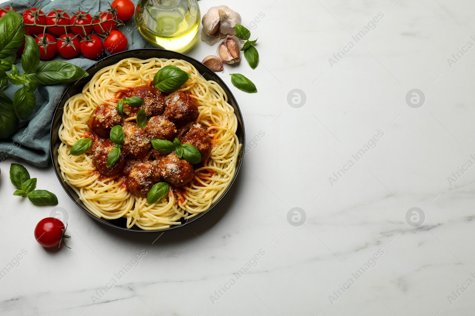 Photo of Delicious pasta with meatballs and ingredients on white marble table, flat lay. Space for text