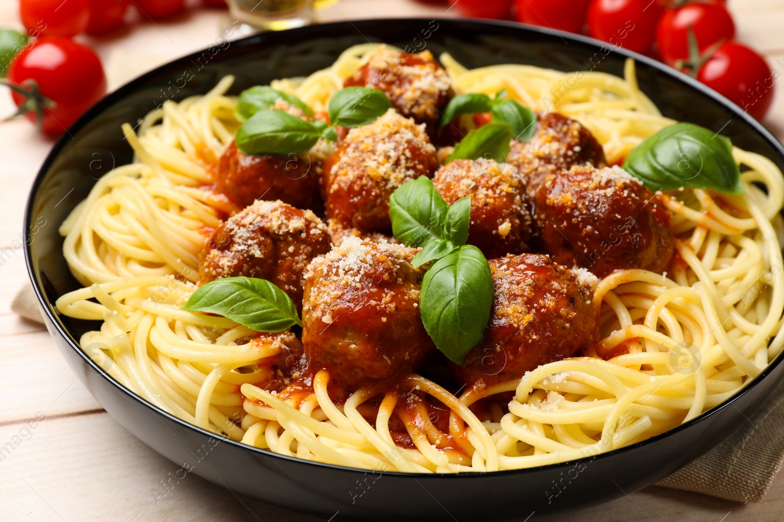 Photo of Delicious pasta with meatballs on wooden table, closeup