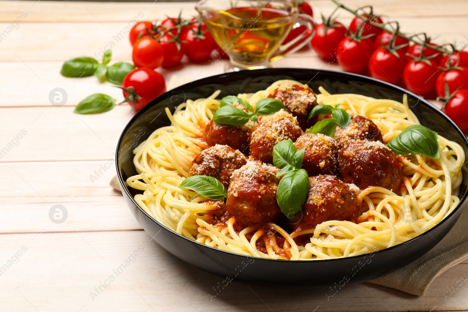 Photo of Delicious pasta with meatballs on wooden table, closeup