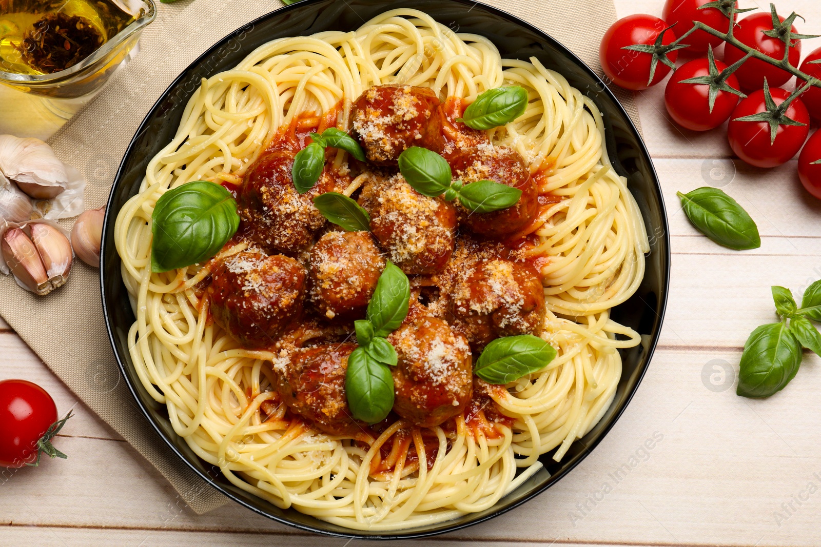 Photo of Delicious pasta with meatballs and ingredients on wooden table, flat lay