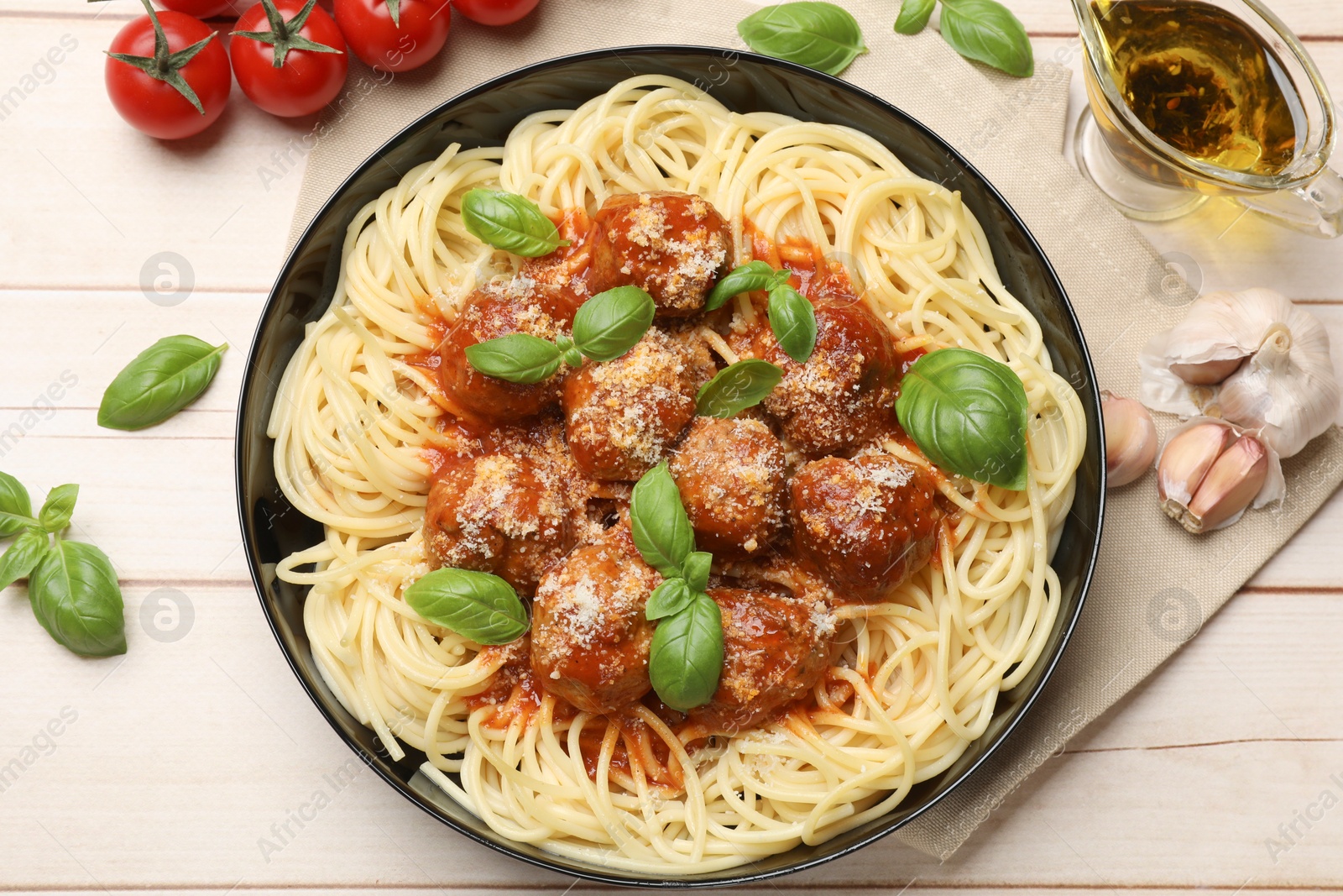 Photo of Delicious pasta with meatballs and ingredients on wooden table, flat lay