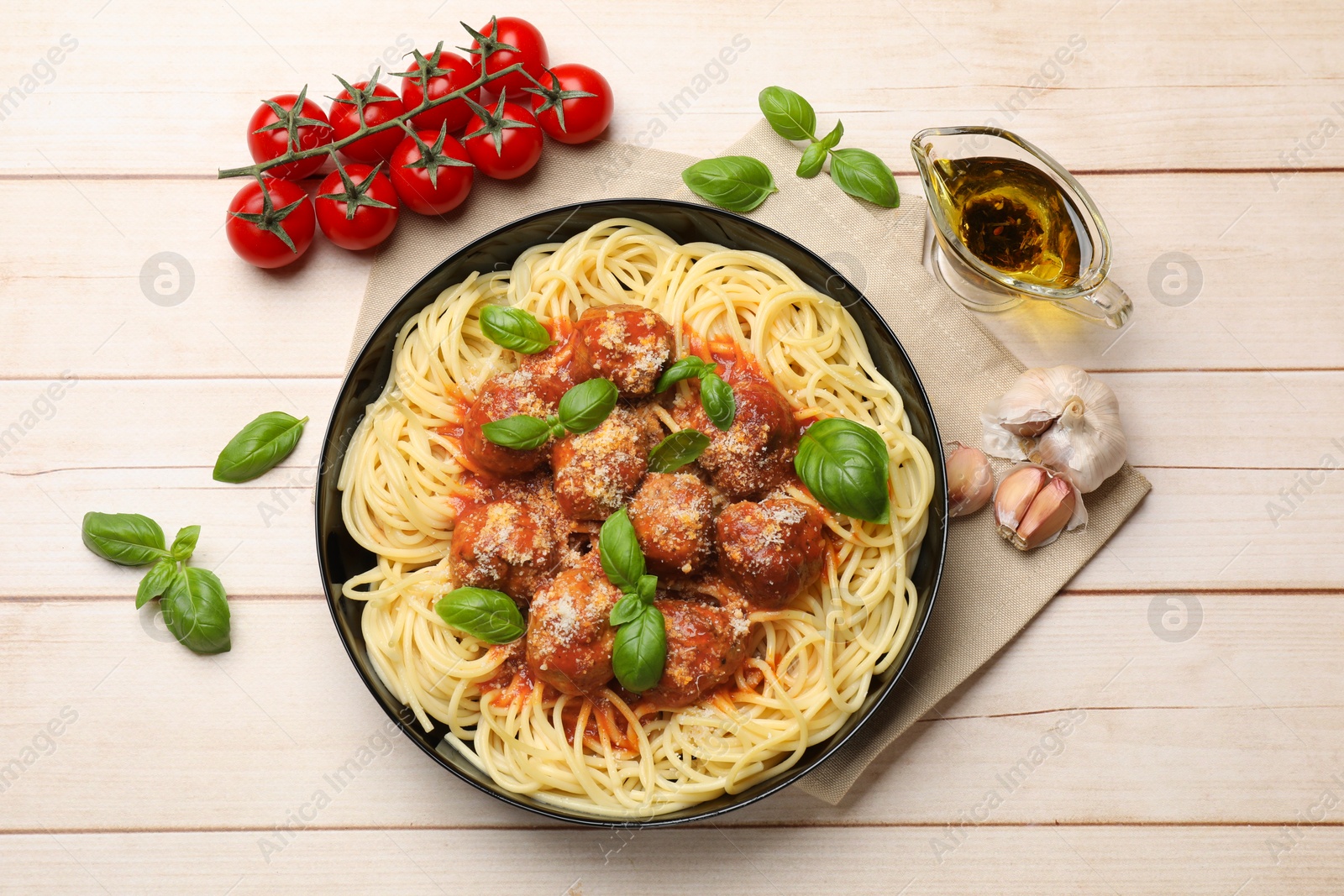 Photo of Delicious pasta with meatballs and ingredients on wooden table, flat lay