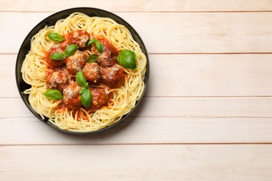 Delicious pasta with meatballs on wooden table, top view. Space for text