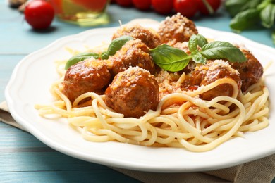 Delicious pasta with meatballs and ingredients on light blue wooden table, closeup