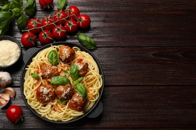 Delicious pasta with meatballs and ingredients on wooden table, flat lay. Space for text