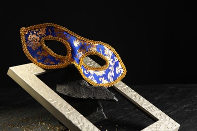 Photo of Beautiful bright carnival mask on dark background