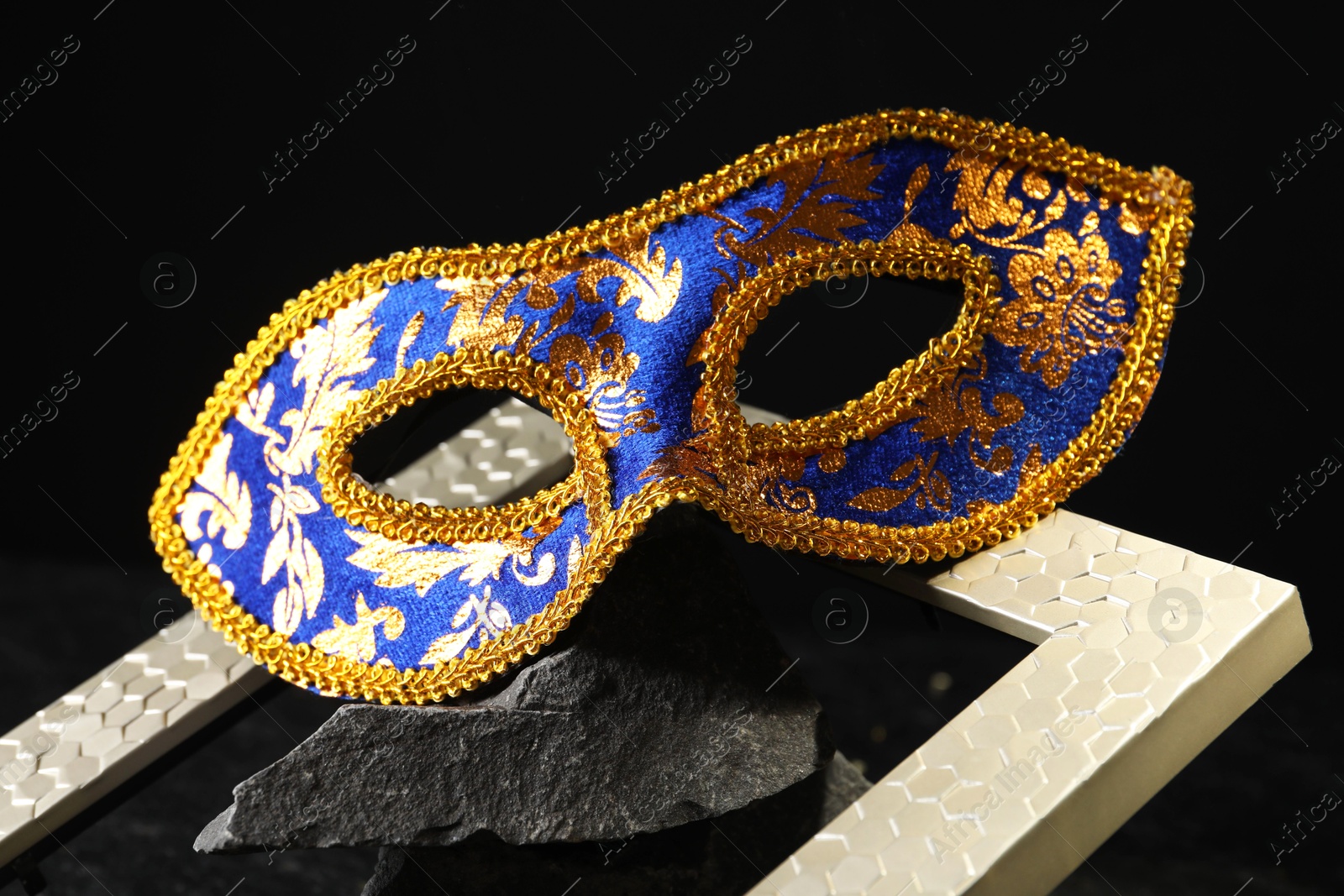 Photo of Beautiful bright carnival mask on dark background