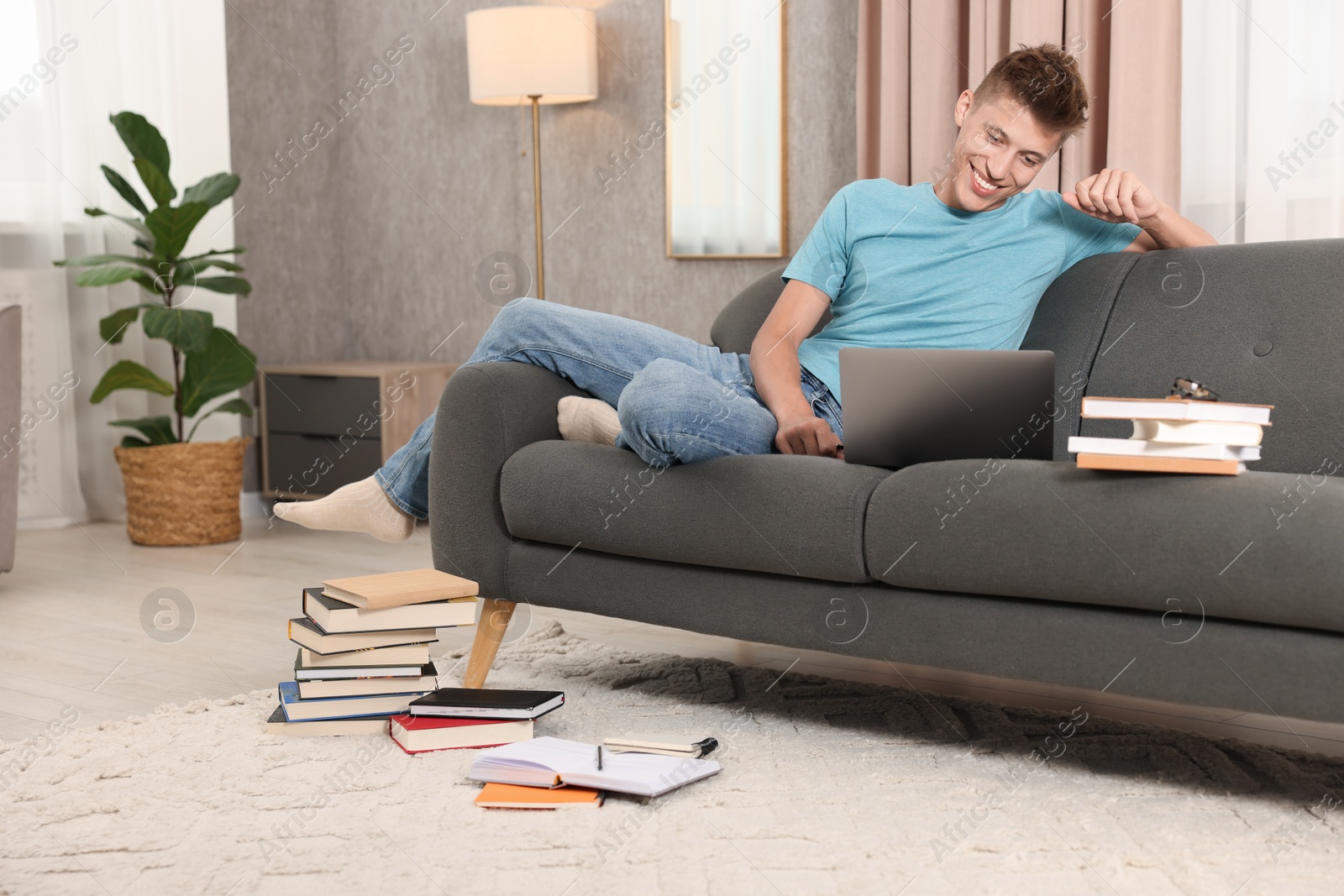 Photo of Student studying with laptop on sofa at home