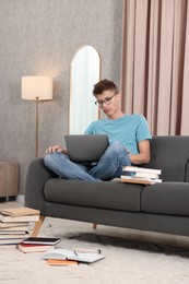 Photo of Student studying with laptop on sofa at home