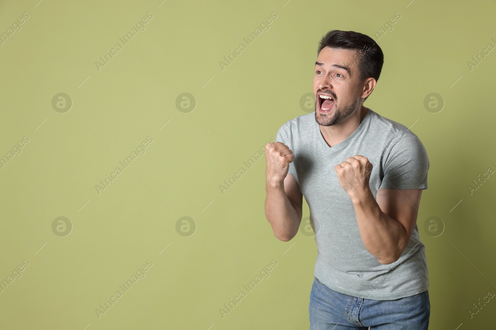 Photo of Portrait of happy winner on pale olive background, space for text