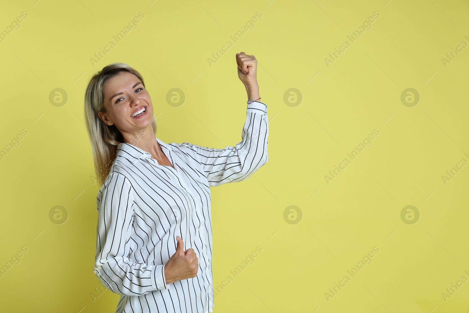 Photo of Happy winner on yellow background, space for text