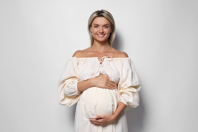 Photo of Portrait of beautiful pregnant woman on white background