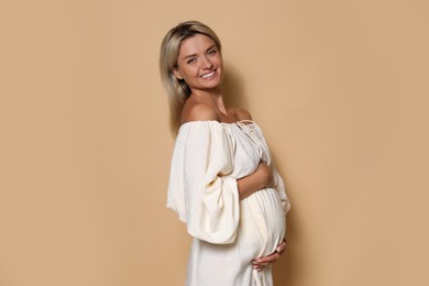 Photo of Portrait of beautiful pregnant woman on beige background