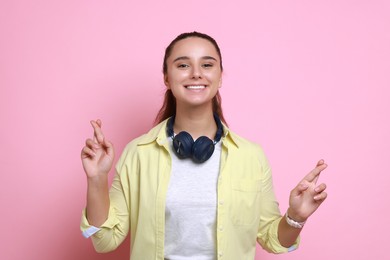 Photo of Excited young student crossing fingers on pink background. Hope for good exam result