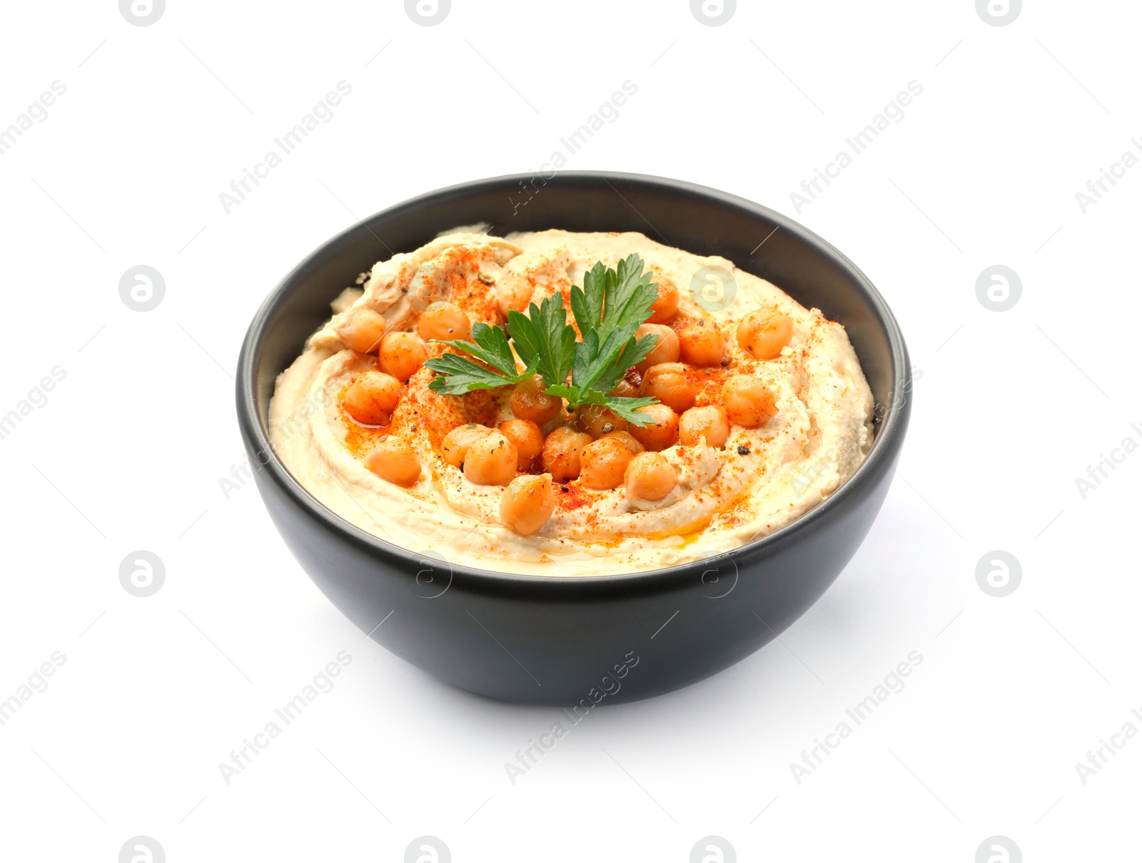 Photo of Delicious hummus with parsley, paprika and chickpeas in bowl isolated on white