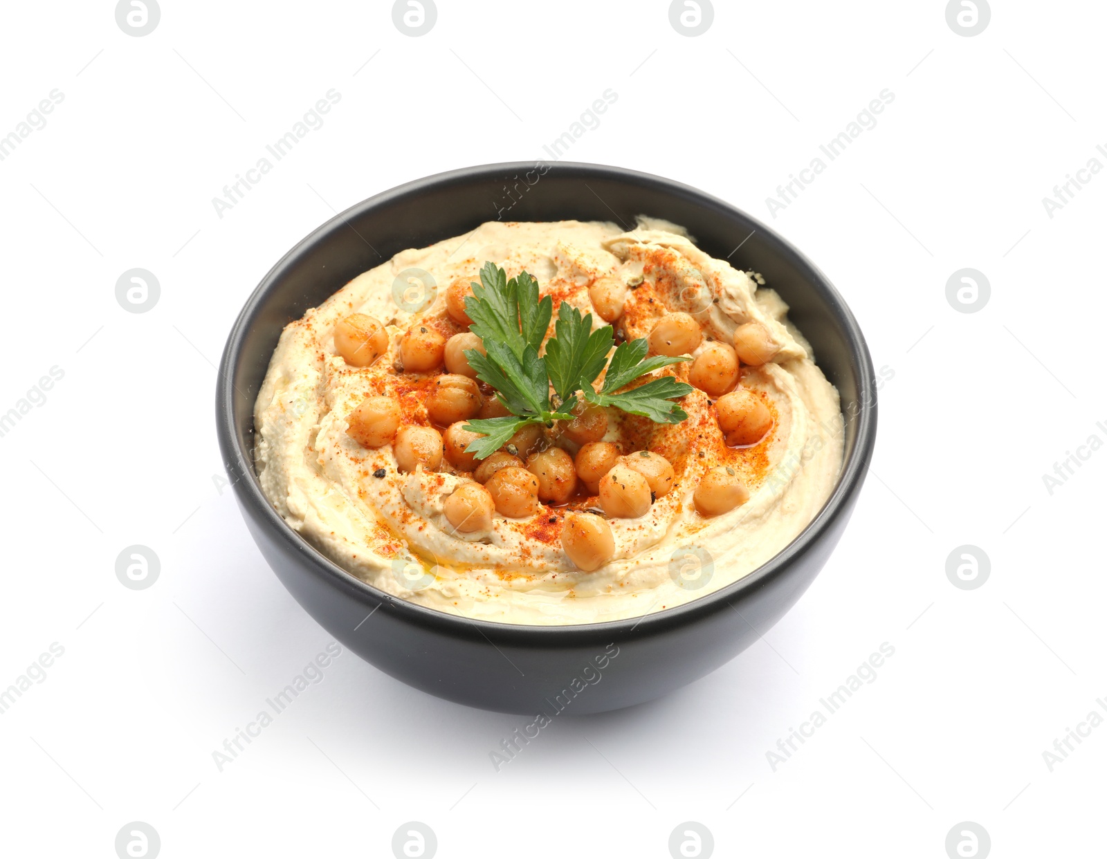 Photo of Delicious hummus with parsley, paprika and chickpeas in bowl isolated on white