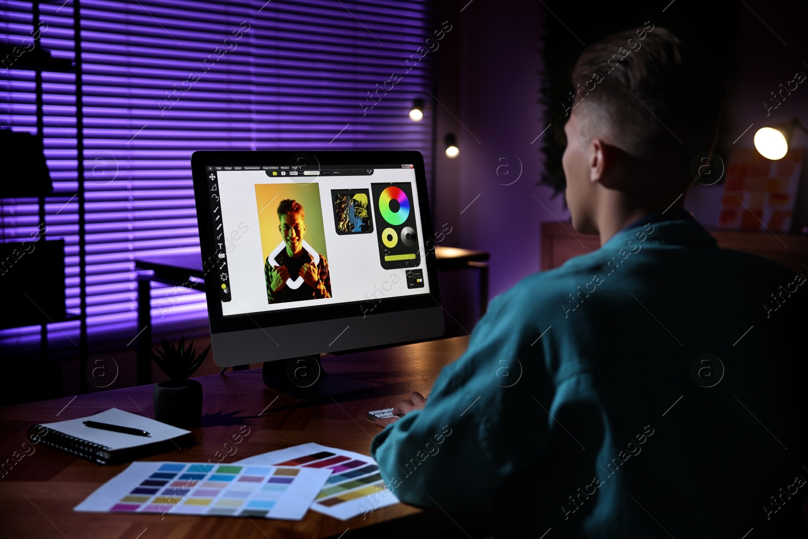 Photo of Designer working on computer indoors at night