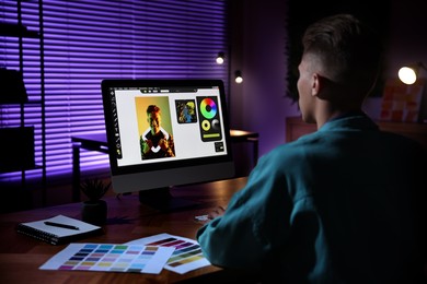 Designer working on computer indoors at night